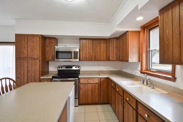 a kitchen with a sink a stove a refrigerator and a microwave