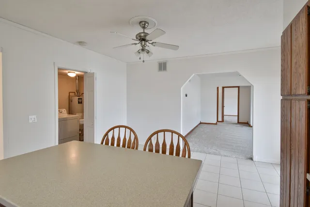a view of a hallway with a dining table and chandelier