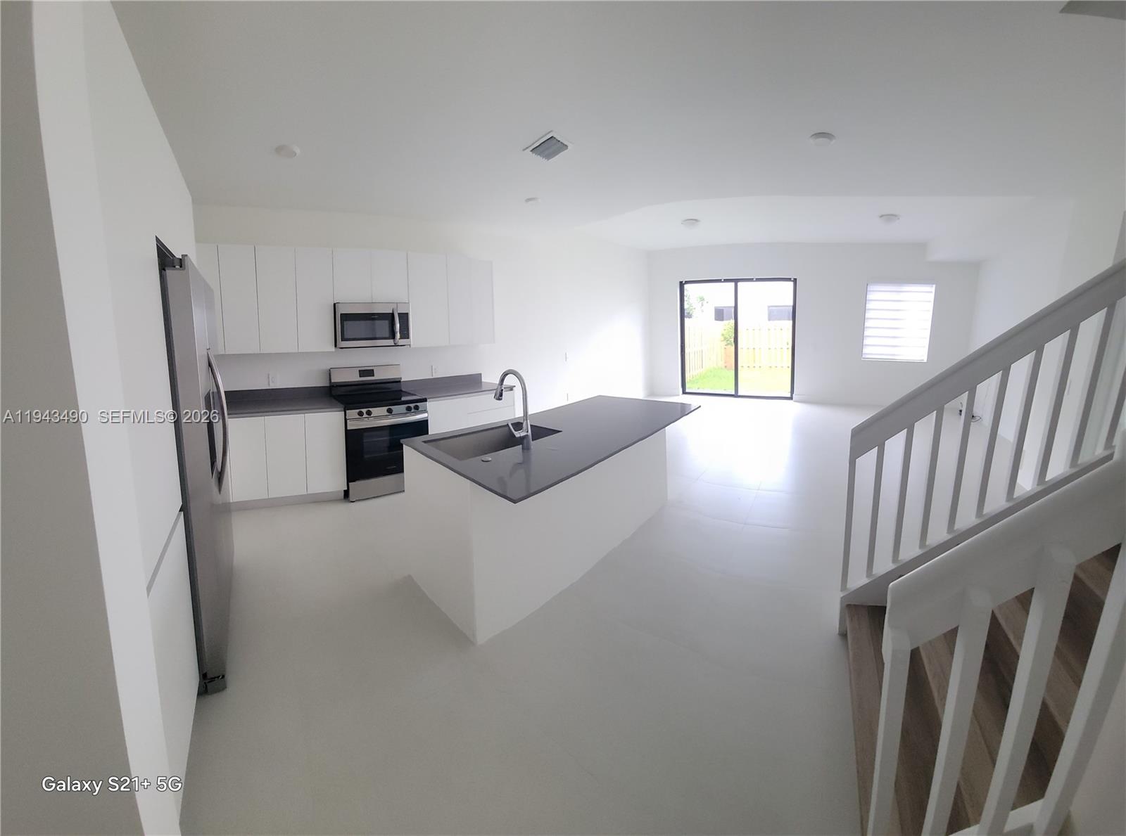 34493 Southwest 191st Court Homestead, FL 33034 - Photo 3 of 12 a living room with stainless steel appliances furniture a window and a view of kitchen