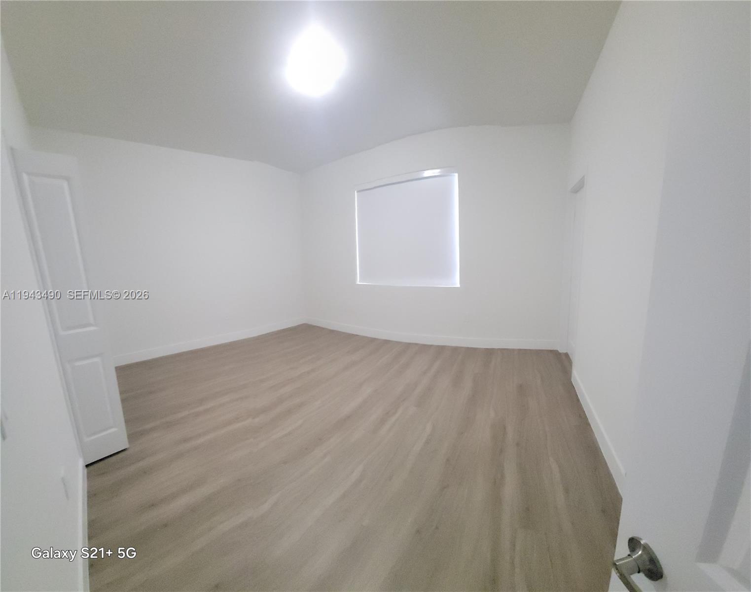 34493 Southwest 191st Court Homestead, FL 33034 - Photo 7 of 12 an empty room with wooden floor and windows