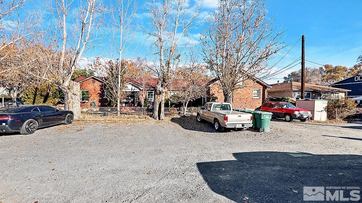a view of road with card parked on side and retail shops
