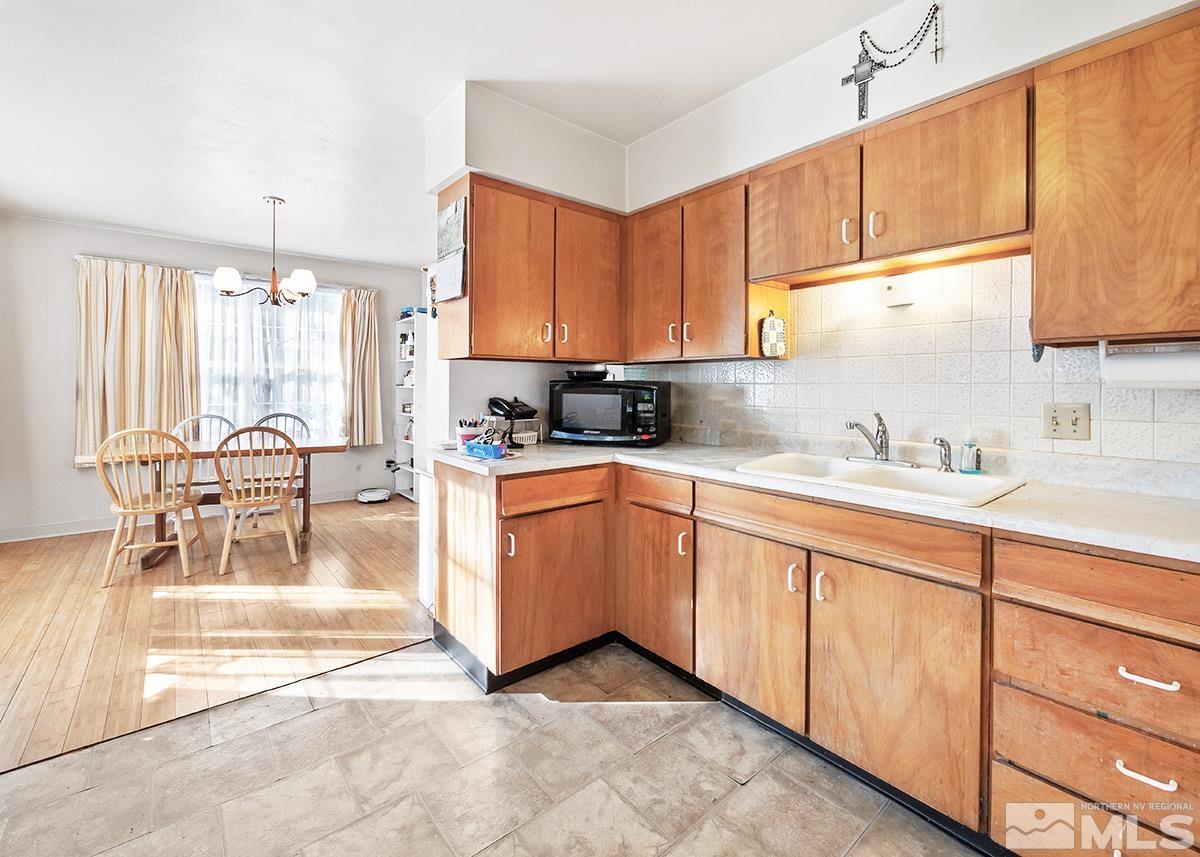412 East 8th Street Reno, NV 89512 - Photo 11 of 40 a kitchen with stainless steel appliances granite countertop a stove top oven a sink a dining table and chairs with white cabinets