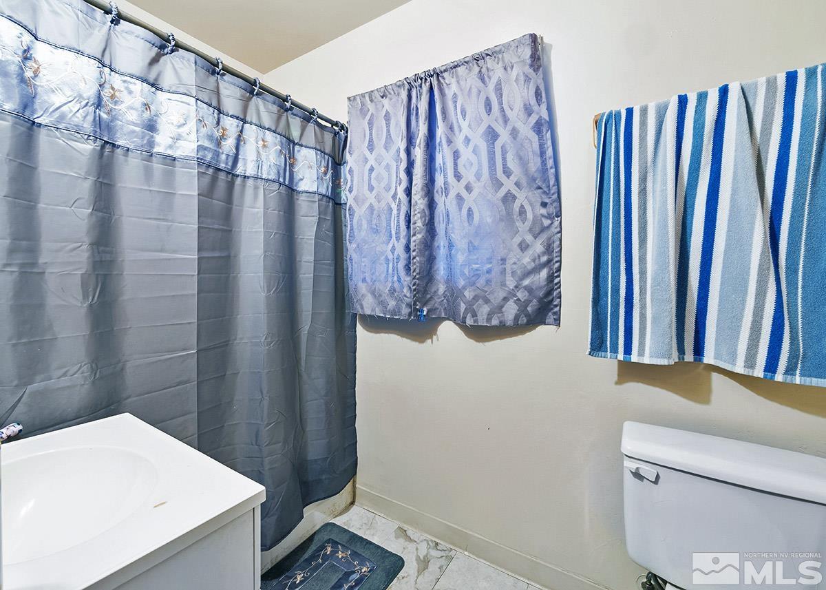412 East 8th Street Reno, NV 89512 - Photo 30 of 40 a bathroom with a shower curtain and a sink