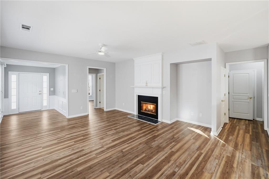 3901 Delfaire Trace Cumming, GA 30040 - Photo 14 of 45 a view of empty room with wooden floor and fireplace