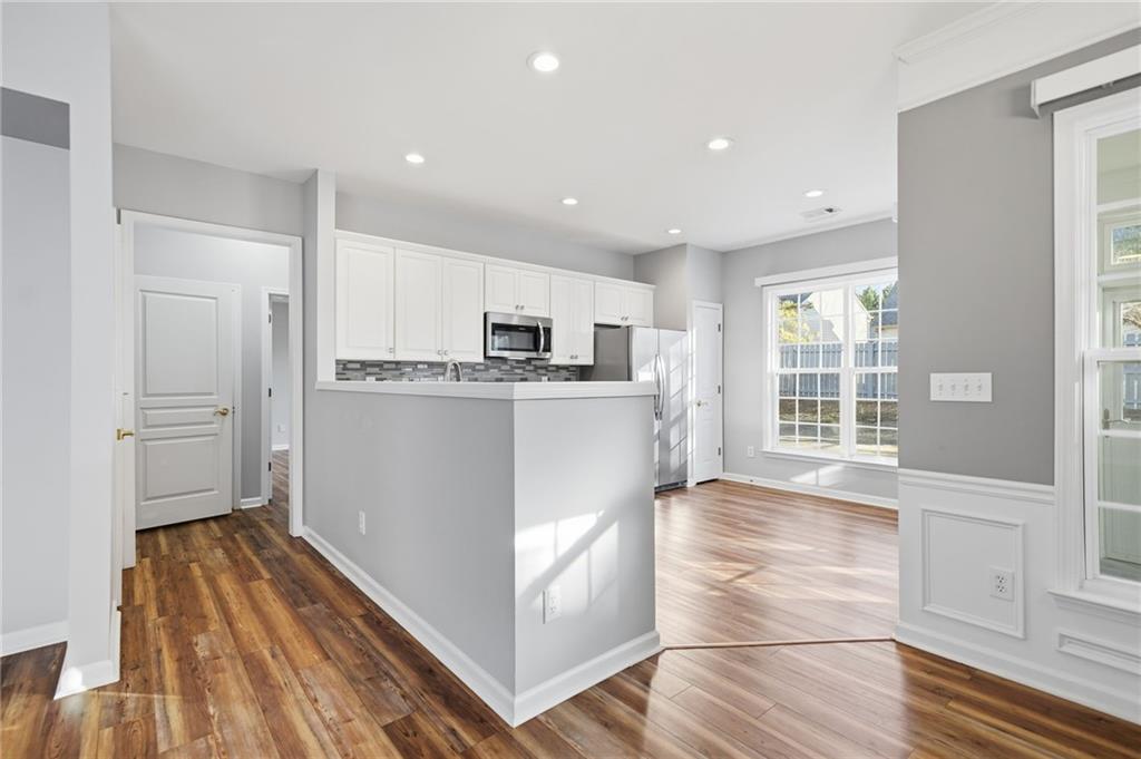 3901 Delfaire Trace Cumming, GA 30040 - Photo 18 of 45 a kitchen with stainless steel appliances granite countertop a refrigerator a sink a stove and white cabinets with wooden floor
