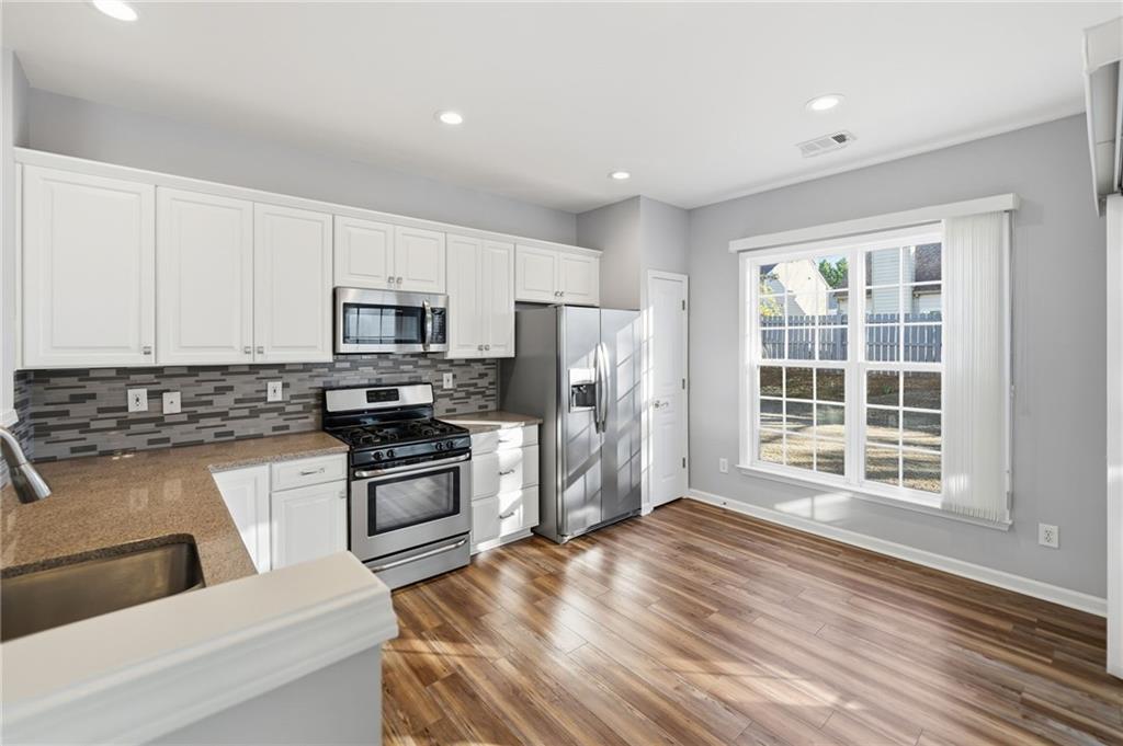3901 Delfaire Trace Cumming, GA 30040 - Photo 19 of 45 a kitchen with granite countertop a stove a sink and a refrigerator