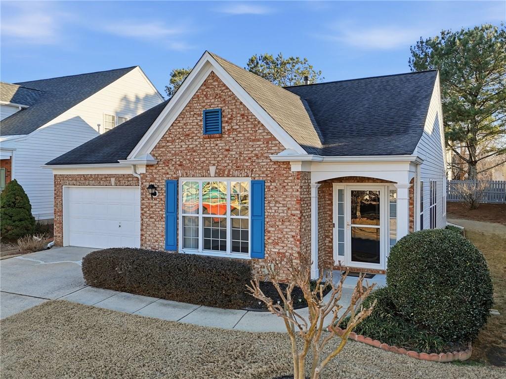 3901 Delfaire Trace Cumming, GA 30040 - Photo 4 of 45 a view of a brick house with large windows and plants