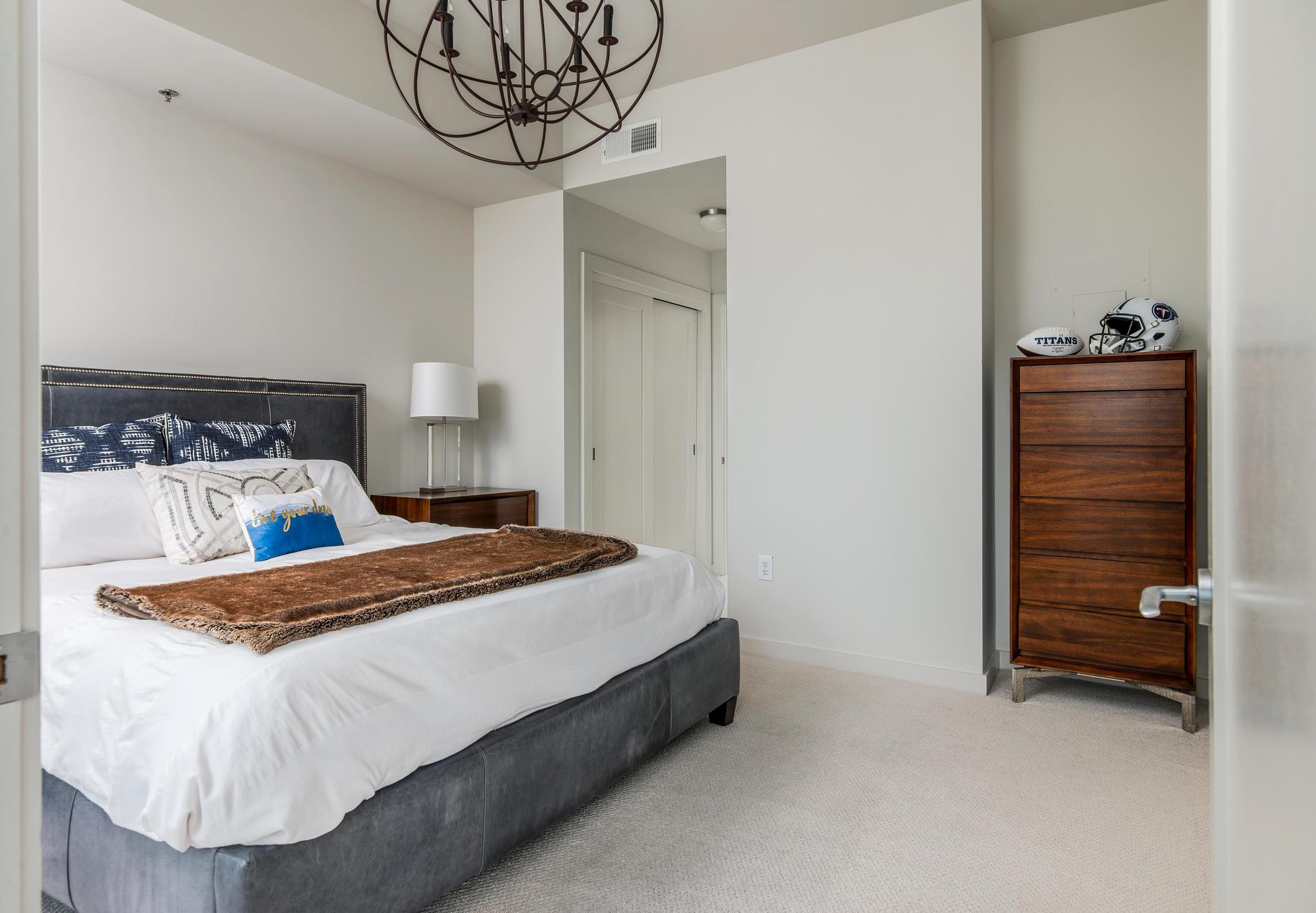 900 20th Avenue South, Unit 1001 Nashville, TN 37212 - Photo 15 of 30 a bedroom with a bed and a chair