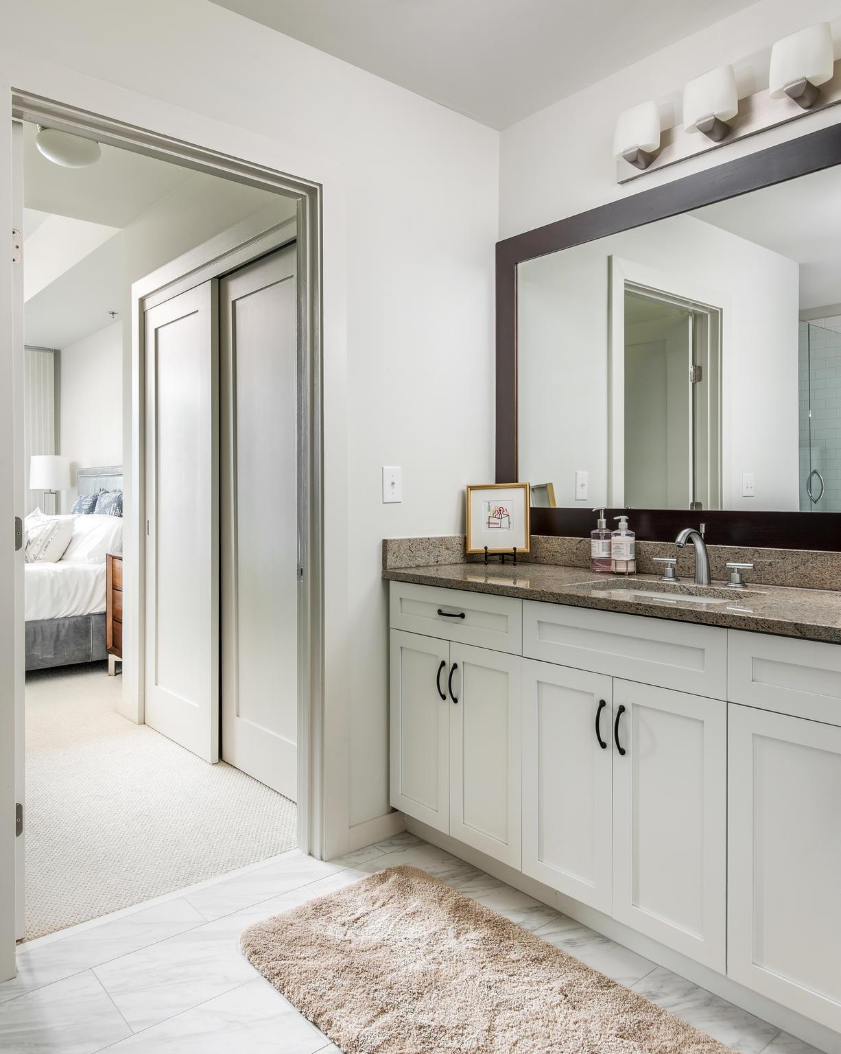 900 20th Avenue South, Unit 1001 Nashville, TN 37212 - Photo 17 of 30 a spacious bathroom with a granite countertop sink and a mirror