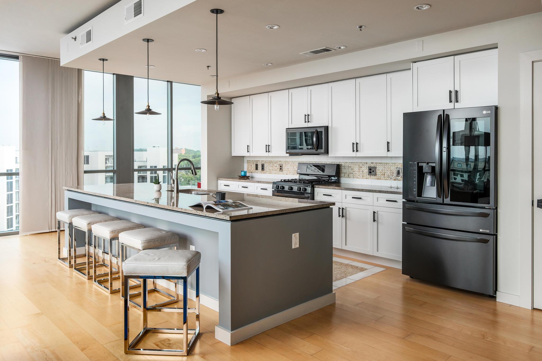 900 20th Avenue South, Unit 1001 Nashville, TN 37212 - Photo 4 of 30 a kitchen with kitchen island white cabinets and stainless steel appliances