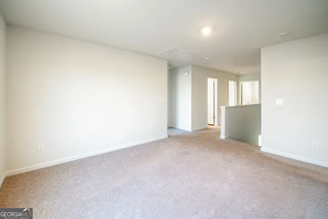 an empty room with a window and a kitchen