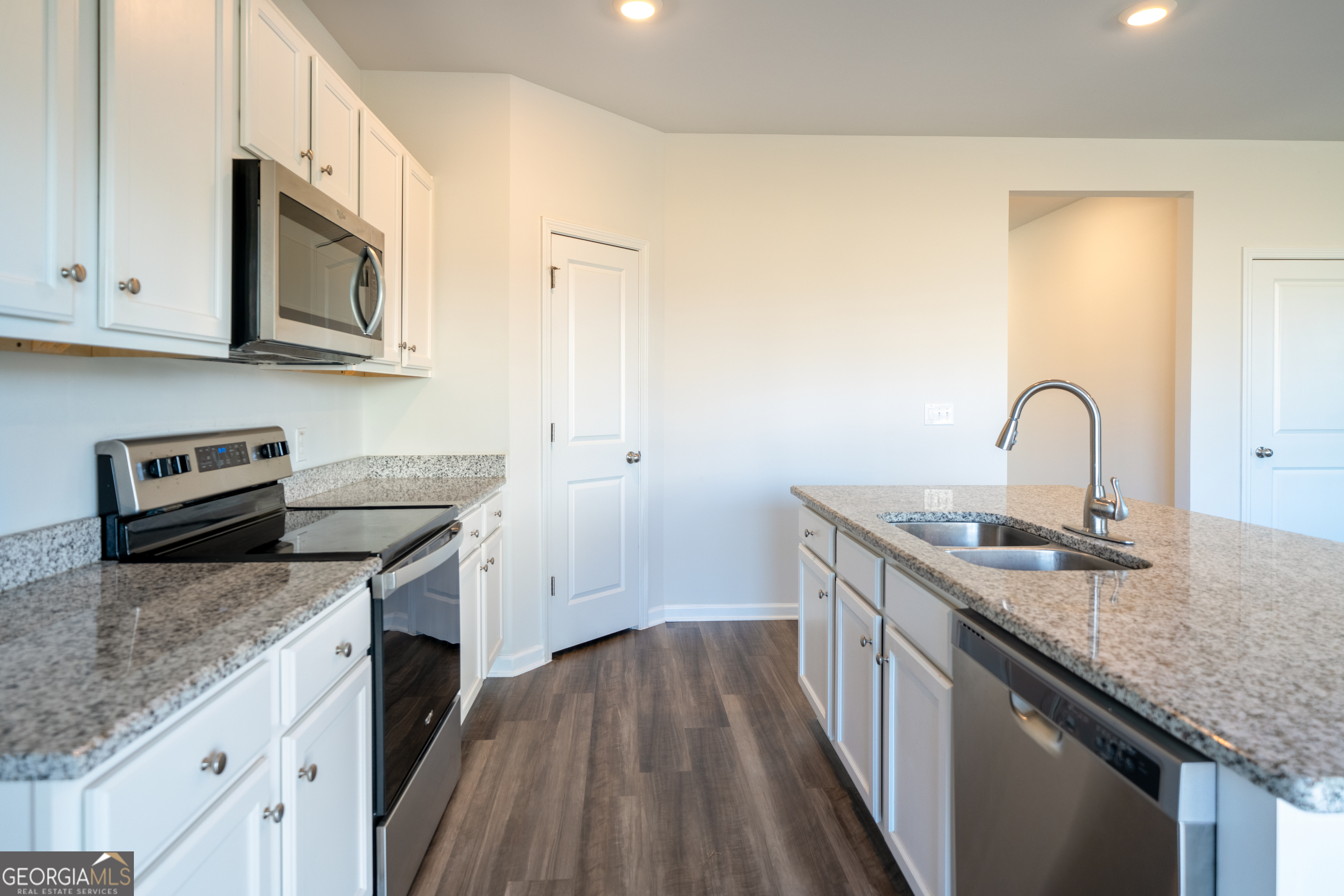 132 Fresh Laurel Lane Locust Grove, GA 30248 - Photo 6 of 24 a kitchen with granite countertop stainless steel appliances a stove sink and microwave