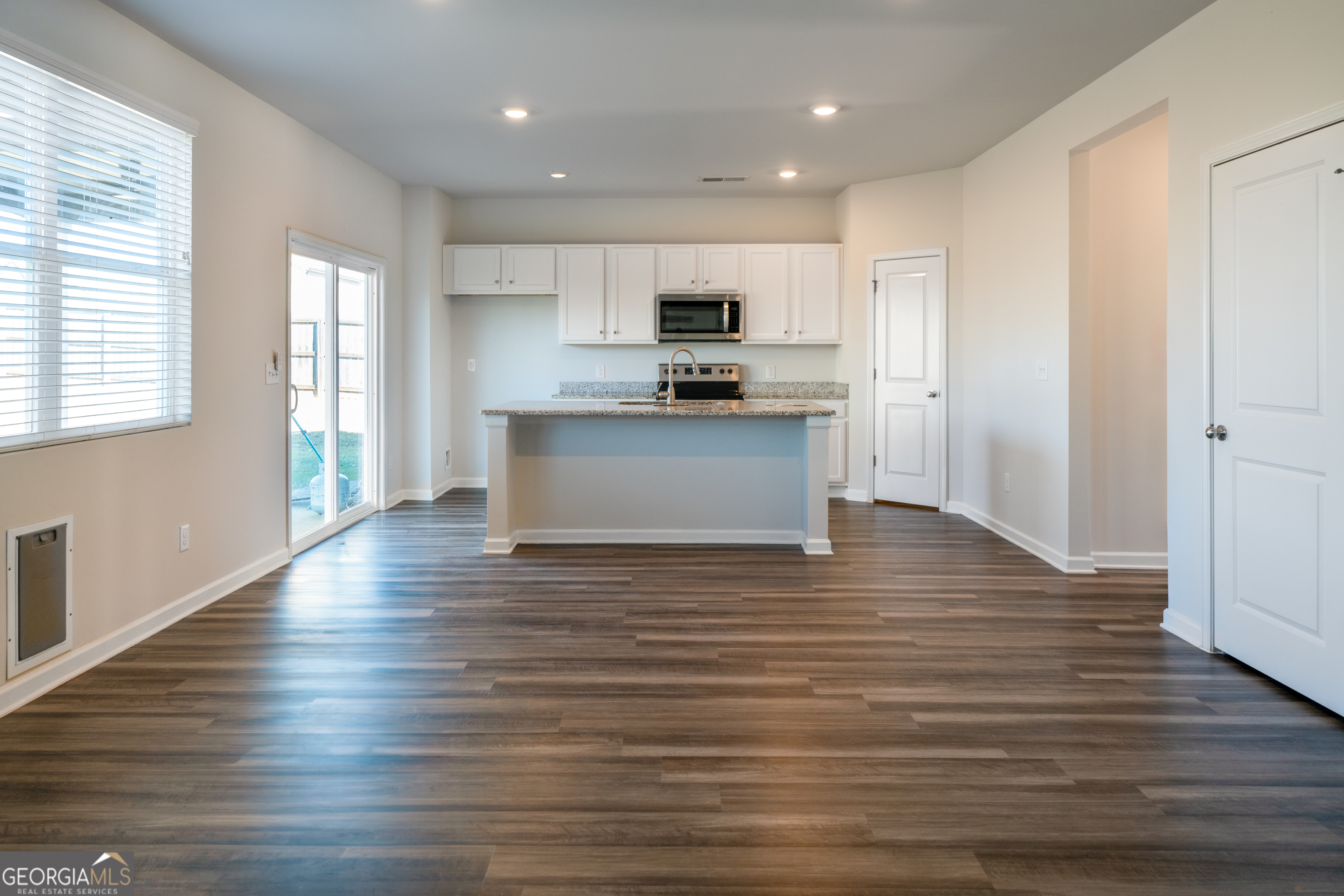 132 Fresh Laurel Lane Locust Grove, GA 30248 - Photo 7 of 24 a view of kitchen with kitchen island granite countertop wooden floor and stainless steel appliances