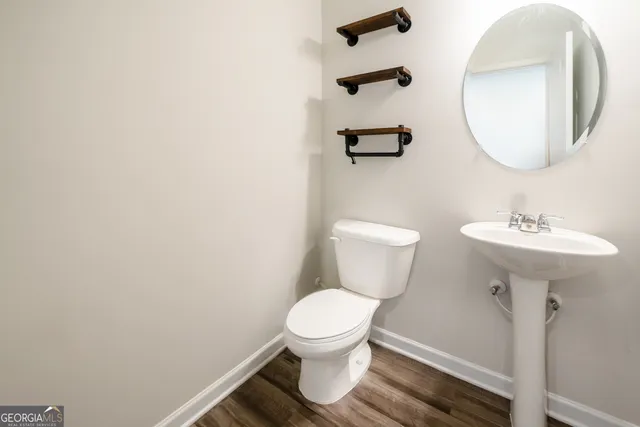 a bathroom with a sink toilet and a mirror