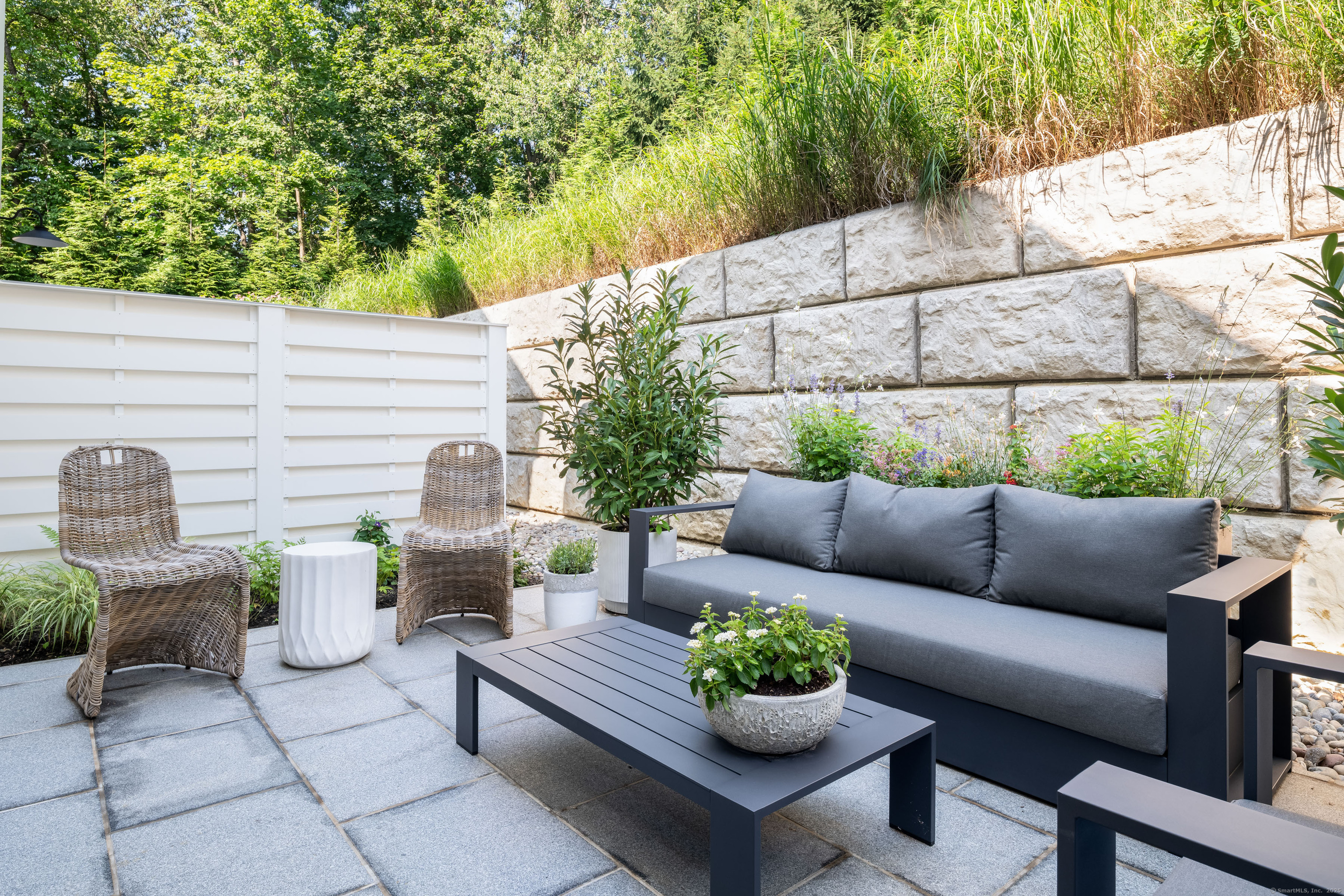 785 Post Road East, Unit 302 Westport, CT 06880 - Photo 16 of 39 a view of a patio with couches and a potted plant on a table and chair