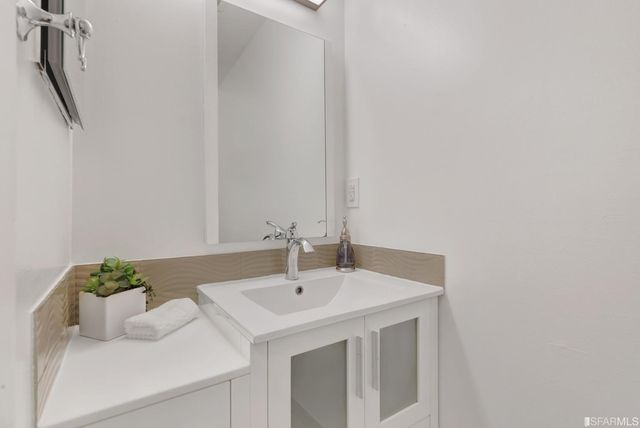 a view of a room with wooden floor and a ceiling fan