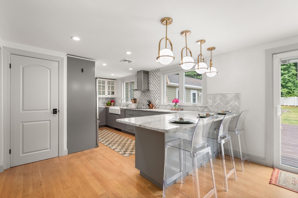 57 Marlboro Road Sudbury, MA 01776 - Photo 5 of 40 a kitchen with stainless steel appliances kitchen island granite countertop a table chairs and a chandelier
