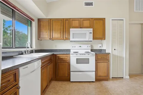 a kitchen with a stove sink and cabinets