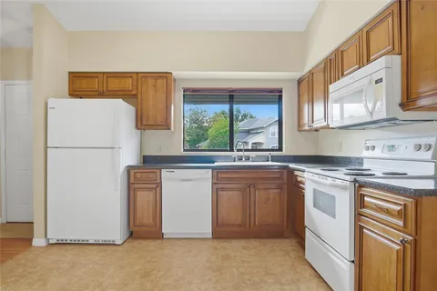 a kitchen with appliances a sink and a refrigerator