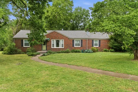 a front view of a house with a yard and trees