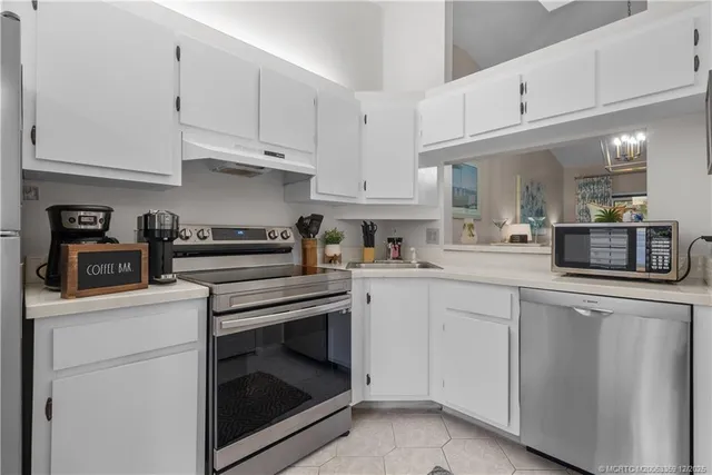 a kitchen with white cabinets and appliances