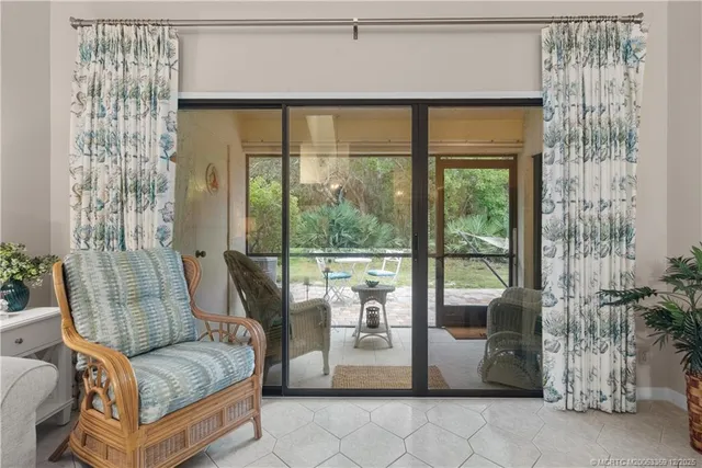 a living room with furniture and a floor to ceiling window