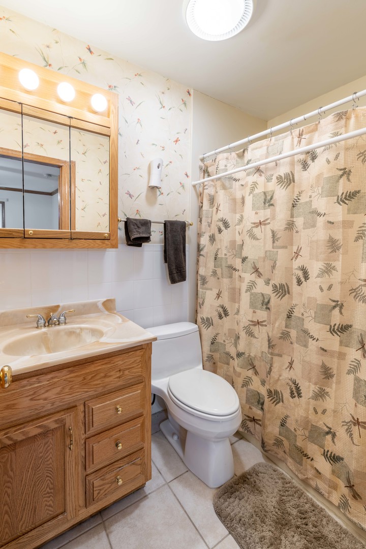 215 Fernwood Road Montgomery, IL 60538 - Photo 11 of 18 a bathroom with a granite countertop bathtub sink mirror vanity and toilet