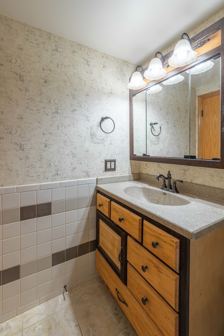 215 Fernwood Road Montgomery, IL 60538 - Photo 16 of 18 a bathroom with a granite countertop sink a mirror and a shower