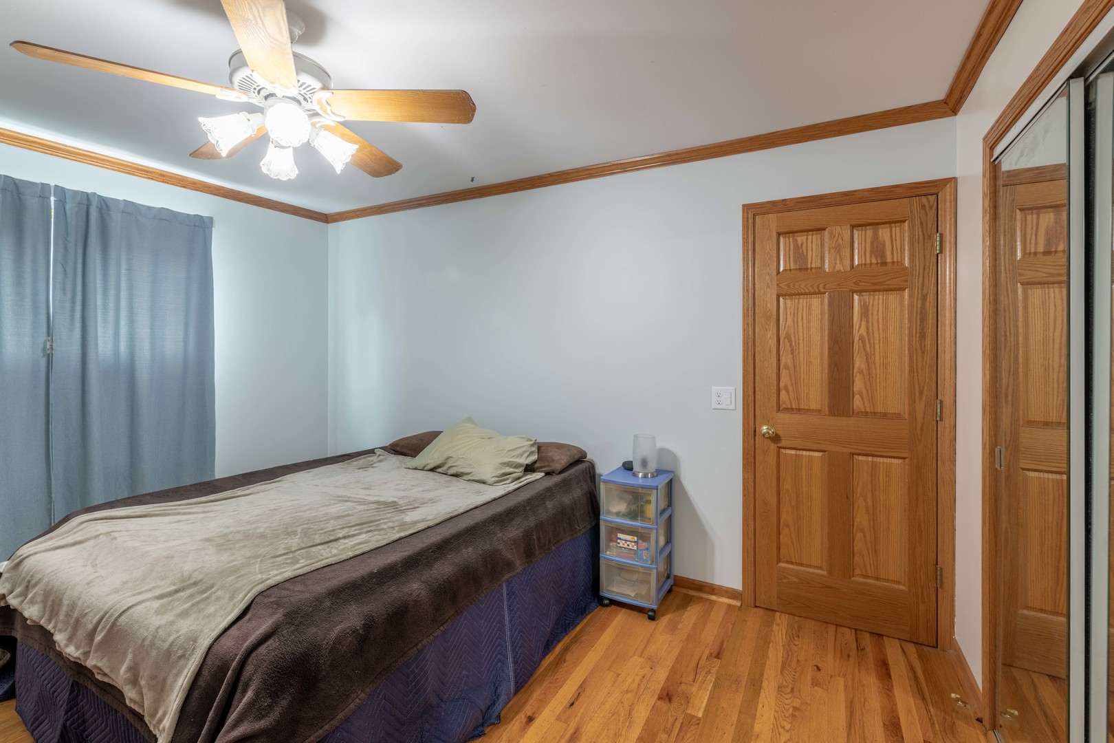 215 Fernwood Road Montgomery, IL 60538 - Photo 7 of 18 a bedroom with a bed and a chandelier