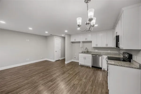 a kitchen with stainless steel appliances granite countertop a sink cabinets a stove and a refrigerator