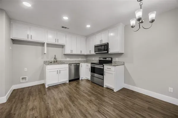 a kitchen with a sink stainless steel appliances and white cabinets