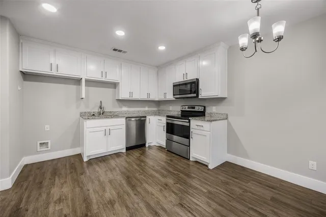 a kitchen with a sink stainless steel appliances and white cabinets