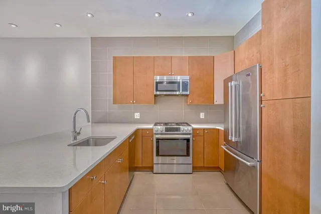 a kitchen with stainless steel appliances granite countertop a refrigerator sink and stove