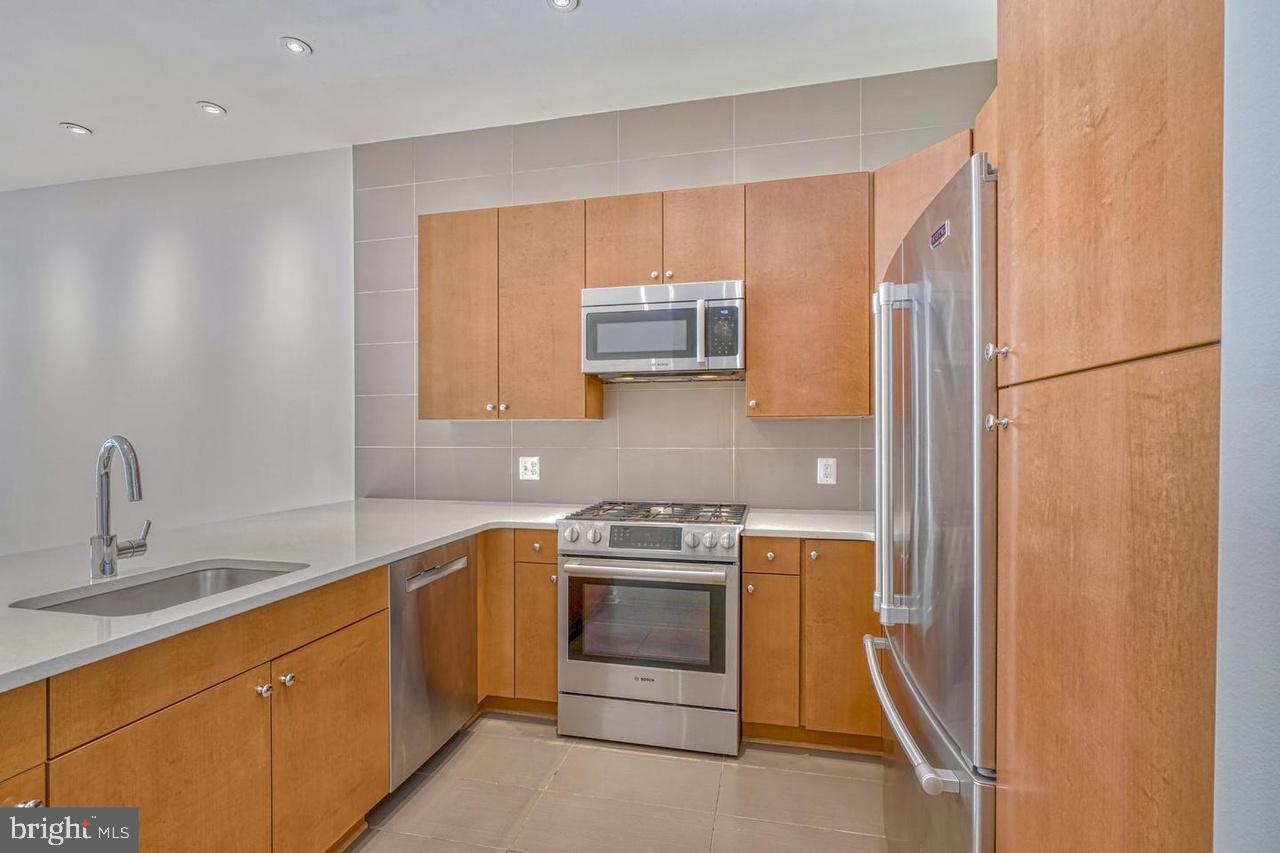 1209 North Charles Street, Unit 309 Baltimore, MD 21201 - Photo 6 of 11 a kitchen with a sink and a refrigerator