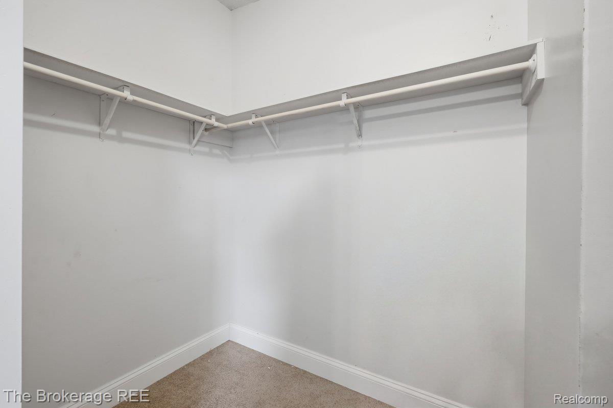 2422 South Henderson Road Davison, MI 48423 - Photo 13 of 53 Built-in shelving and hanging rods with carpeted flooring