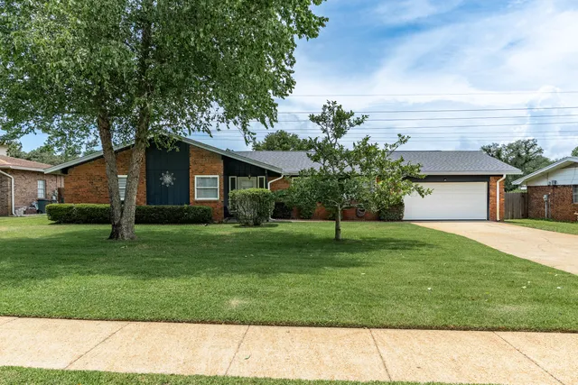 a front view of a house with a yard and trees
