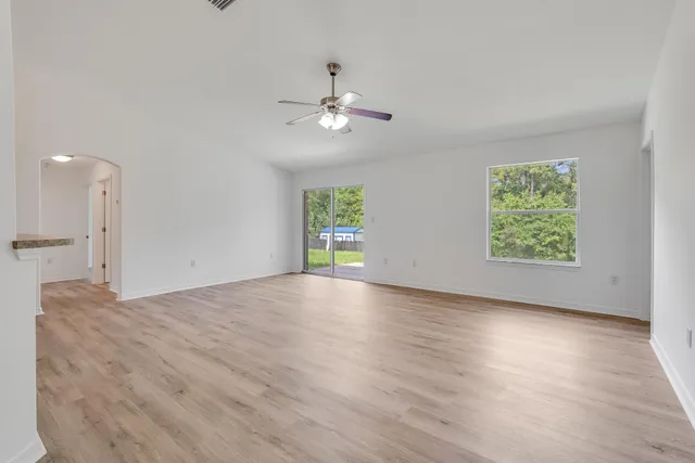 a view of a kitchen with wooden floor and a ceiling fan