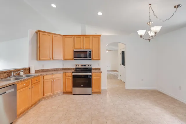 a kitchen with stainless steel appliances granite countertop a stove a sink dishwasher and a refrigerator