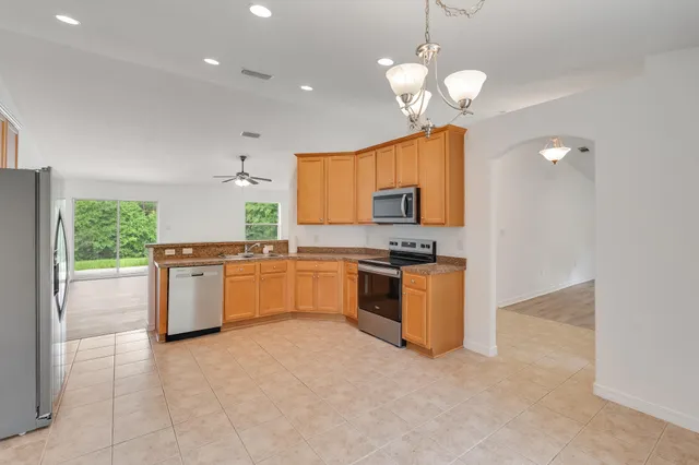 a kitchen with stainless steel appliances granite countertop a sink refrigerator and microwave