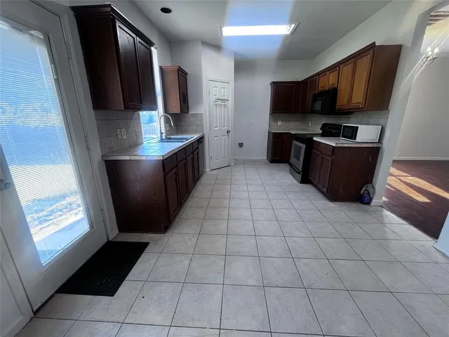 a kitchen with stainless steel appliances a refrigerator and a stove top oven