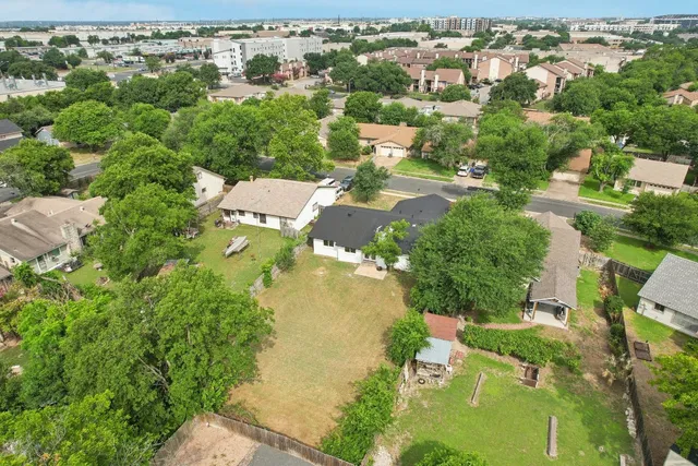 an aerial view of residential house with outdoor space and trees all around