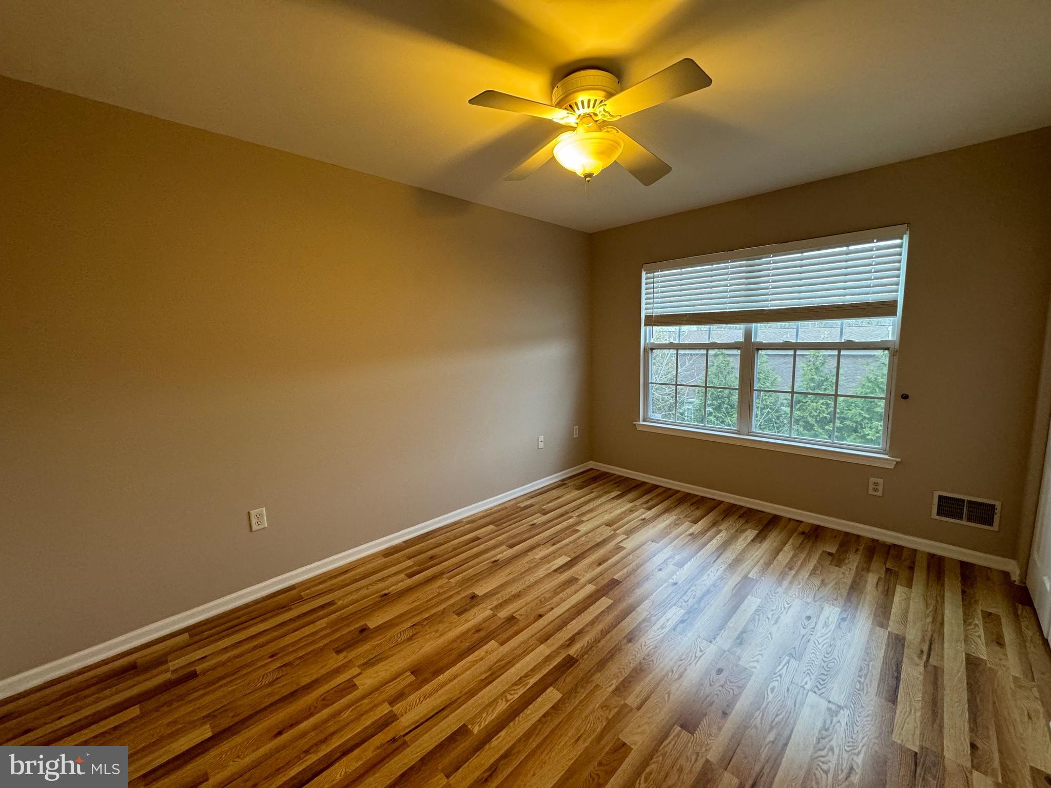 27 Yorkshire Village Road Lawrenceville, NJ 08648 - Photo 14 of 32 a view of an empty room with wooden floor and a window