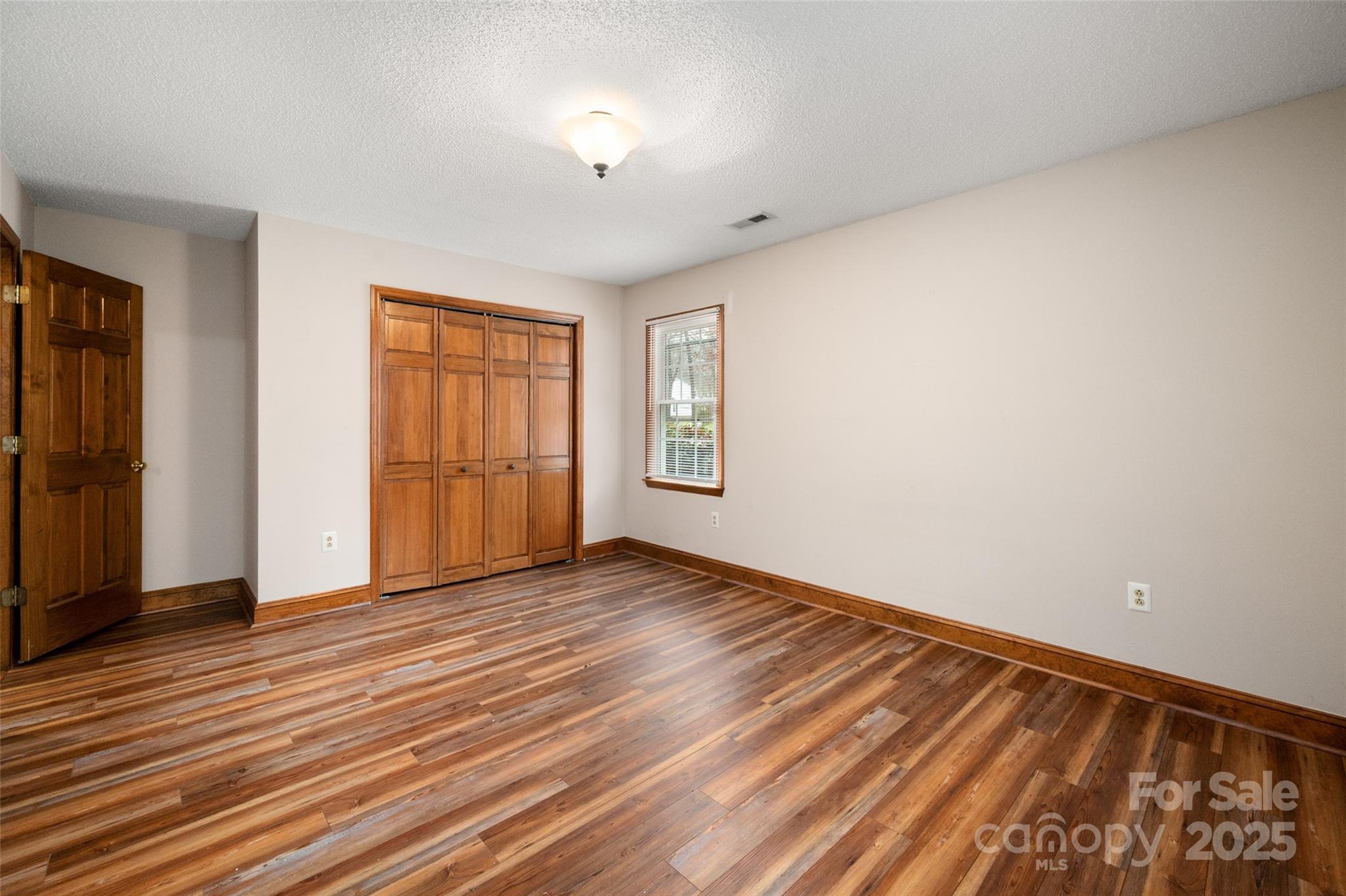 6045 Burnt Mill Run Matthews, NC 28104 - Photo 17 of 32 a view of an empty room with wooden floor and a window