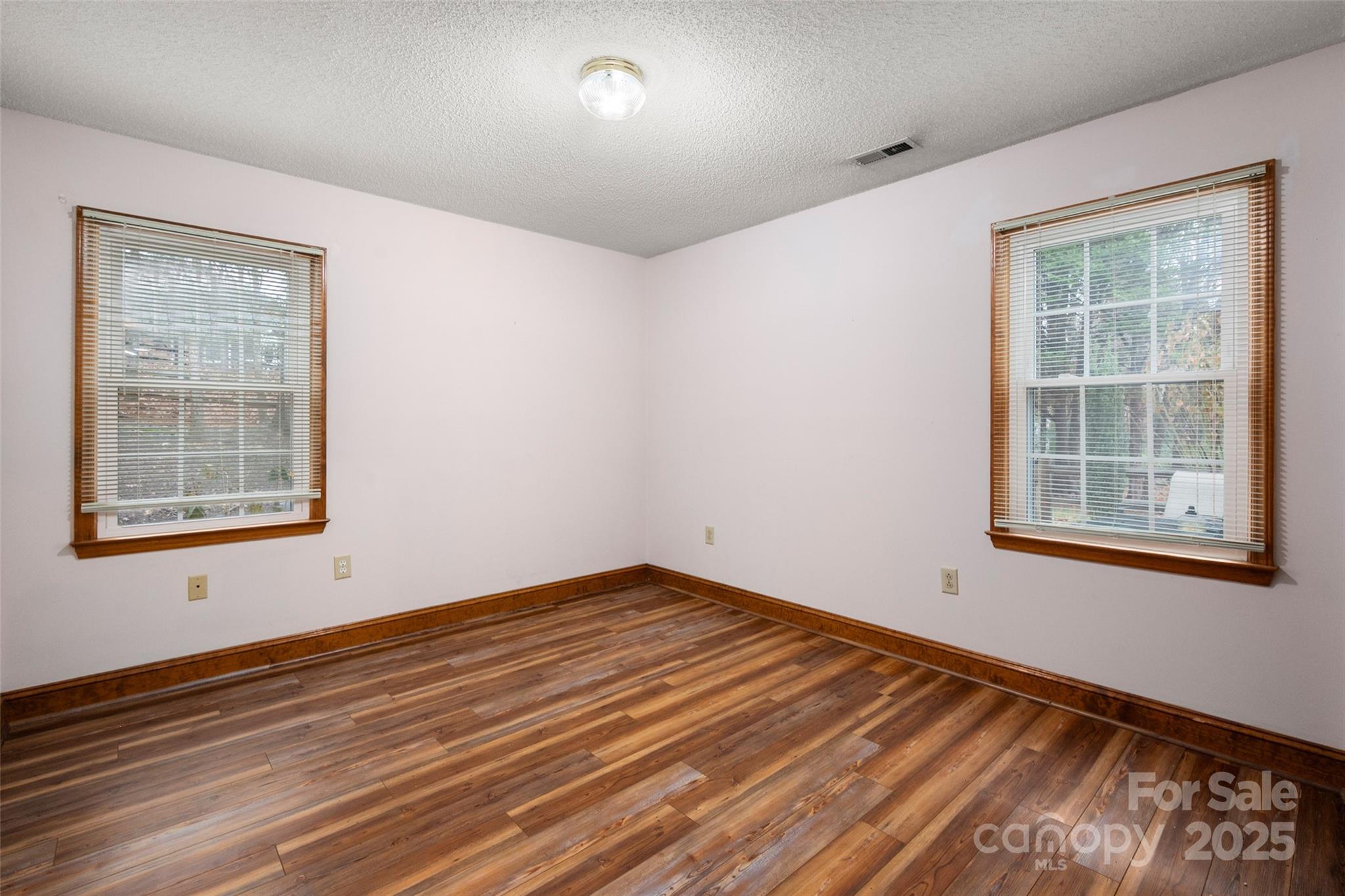 6045 Burnt Mill Run Matthews, NC 28104 - Photo 18 of 32 an empty room with wooden floor and windows