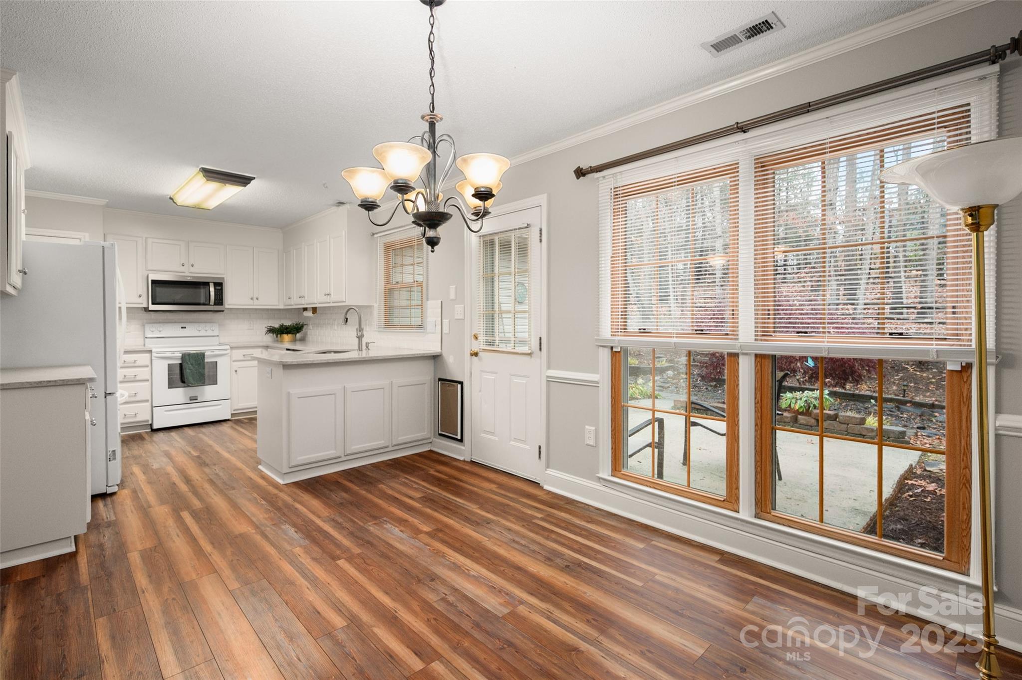 6045 Burnt Mill Run Matthews, NC 28104 - Photo 7 of 32 a view of a kitchen with a sink wooden cabinets and stainless steel appliances