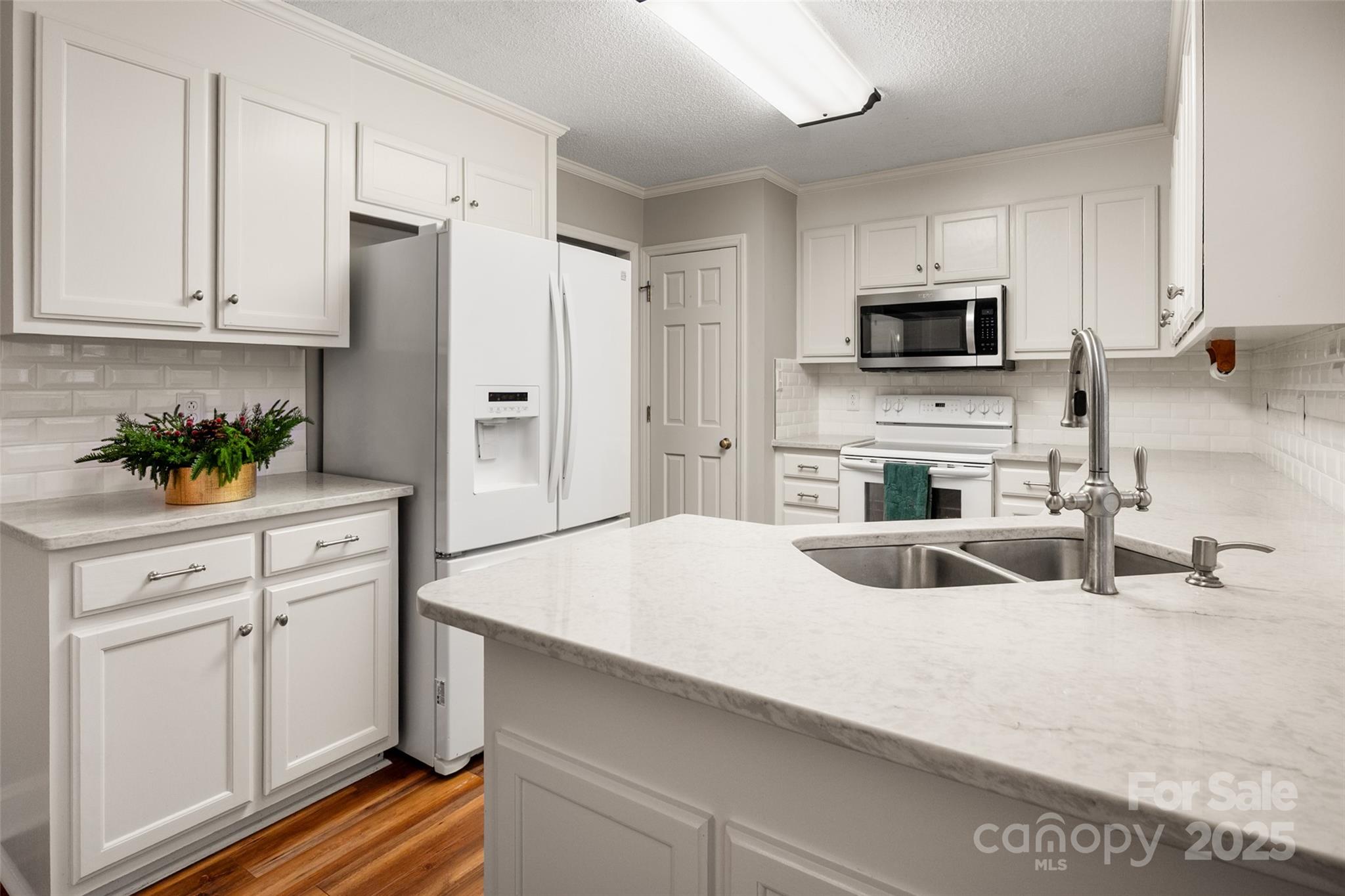 6045 Burnt Mill Run Matthews, NC 28104 - Photo 9 of 32 a kitchen with white cabinets and stainless steel appliances