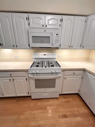 a kitchen with white cabinets and white appliances