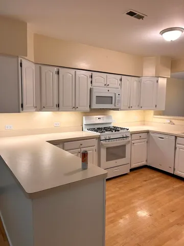 a kitchen with stainless steel appliances a stove a sink and white cabinets