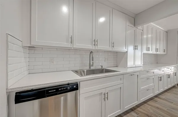 a kitchen with white cabinets and a sink