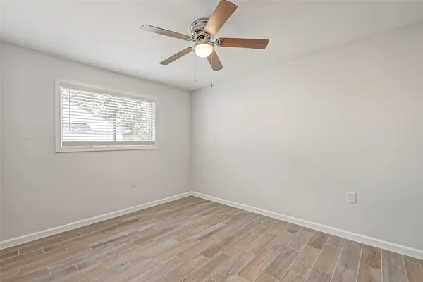 an empty room with a window and a fan